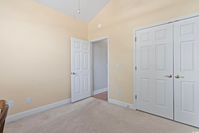 bedroom with a closet, baseboards, carpet floors, and high vaulted ceiling