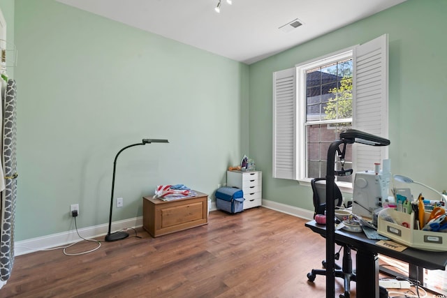 office space featuring visible vents, baseboards, and wood finished floors