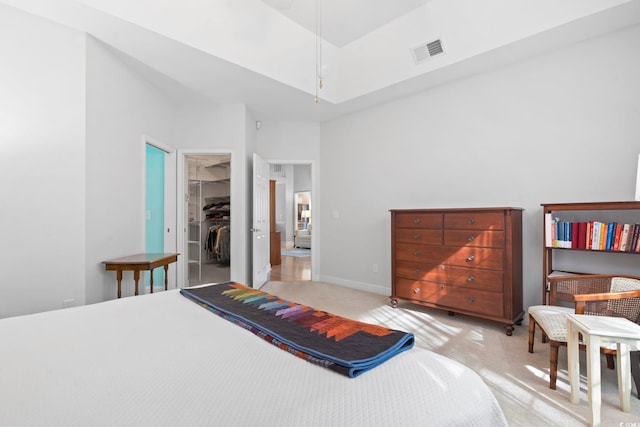 carpeted bedroom with a spacious closet, baseboards, visible vents, and a closet