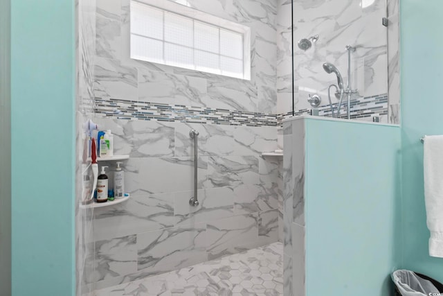 bathroom featuring a marble finish shower