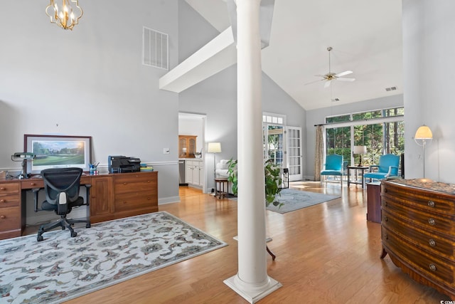 office area featuring light wood-type flooring, visible vents, high vaulted ceiling, a ceiling fan, and decorative columns