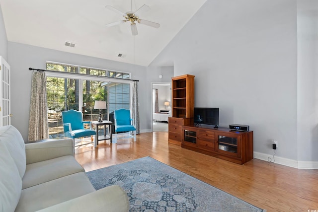 living area with wood finished floors, a ceiling fan, visible vents, and baseboards