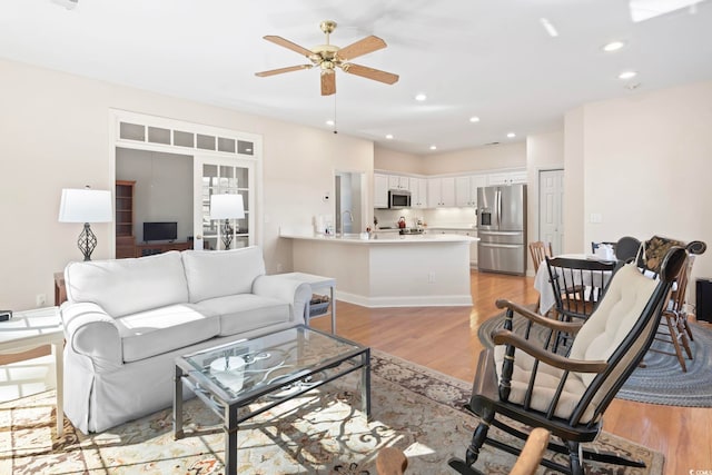 living room with recessed lighting, light wood-style flooring, and ceiling fan