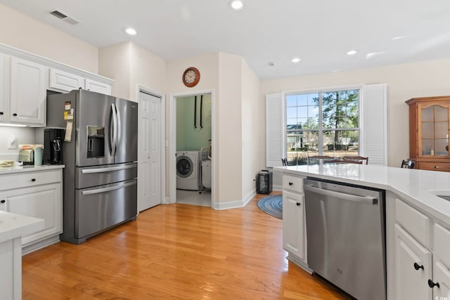 kitchen featuring visible vents, white cabinets, stainless steel appliances, and light countertops