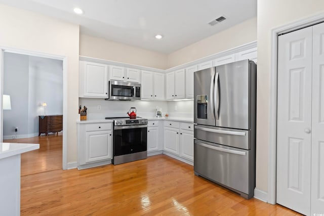 kitchen with white cabinetry, light countertops, visible vents, and stainless steel appliances