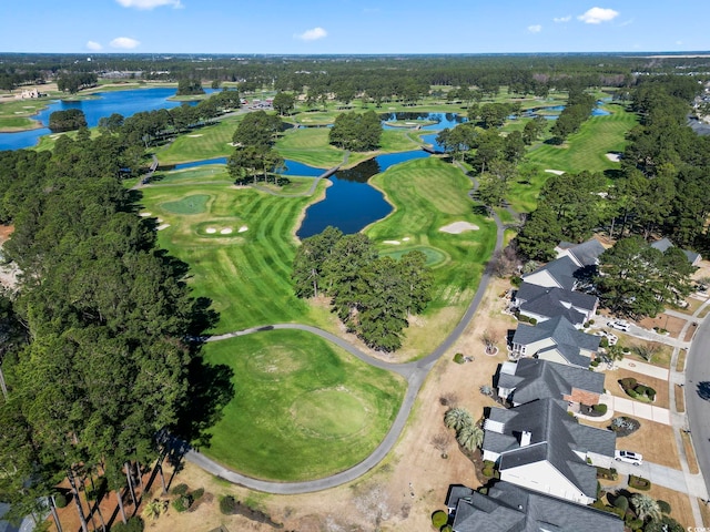 drone / aerial view with golf course view and a water view