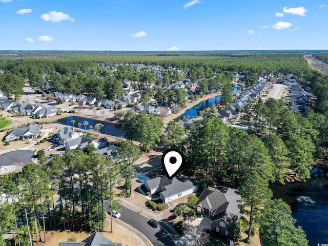 bird's eye view featuring a forest view, a water view, and a residential view