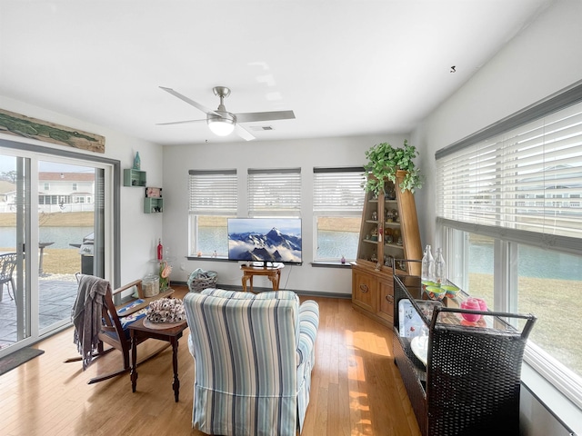 living room with plenty of natural light, light wood-type flooring, and ceiling fan