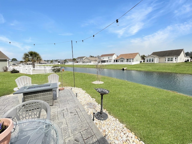 view of patio featuring a residential view, a water view, and fence