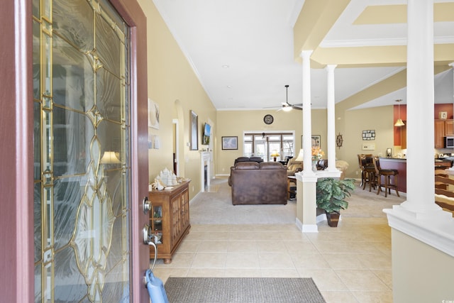 entrance foyer with decorative columns, light tile patterned floors, and ornamental molding