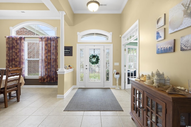 foyer entrance with visible vents, crown molding, baseboards, decorative columns, and light tile patterned floors