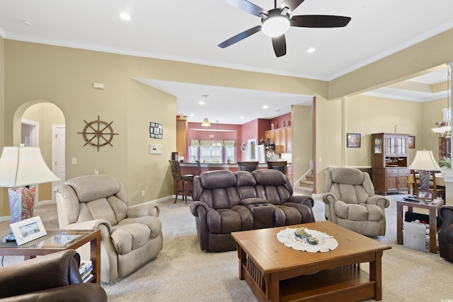 living room with recessed lighting, arched walkways, crown molding, baseboards, and light colored carpet