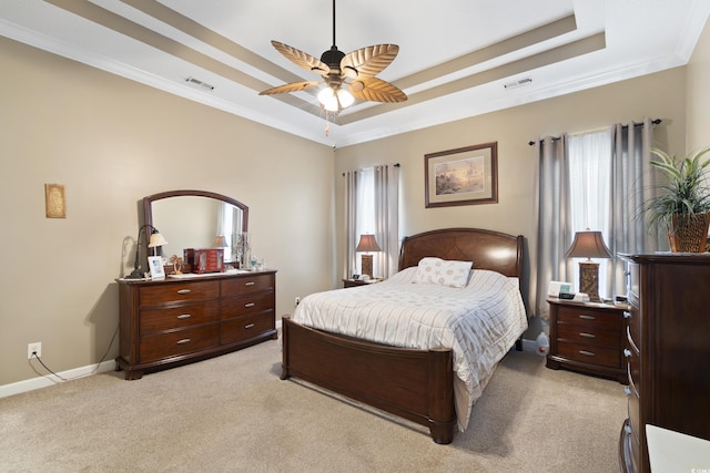 bedroom with visible vents, light colored carpet, baseboards, and a tray ceiling