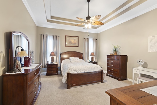 bedroom with a raised ceiling, ornamental molding, a ceiling fan, baseboards, and light colored carpet