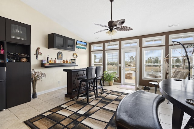 interior space with lofted ceiling, a dry bar, a ceiling fan, and visible vents