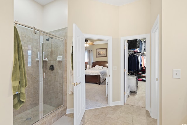 ensuite bathroom featuring a shower stall, ceiling fan, a towering ceiling, tile patterned floors, and ensuite bath