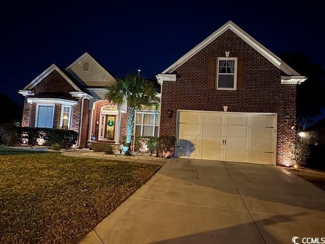 traditional-style house featuring brick siding, driveway, and a garage