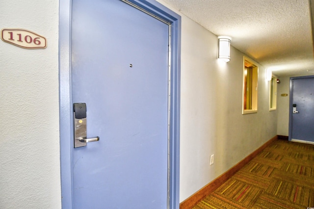 2007 S Ocean Blvd Unit 1106, Myrtle Beach, SC 29577 - hallway featuring a textured ceiling, dark carpet, and baseboards