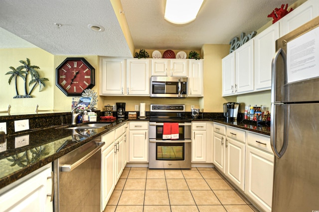 2007 S Ocean Blvd Unit 1106, Myrtle Beach, SC 29577 - kitchen with stainless steel appliances, a sink, light tile patterned floors, white cabinets, and a textured ceiling