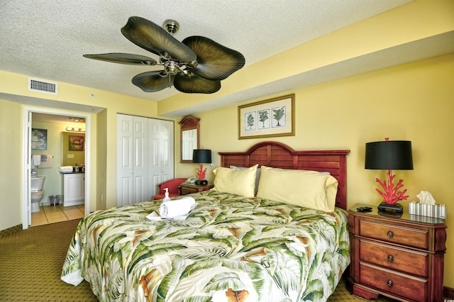 2007 S Ocean Blvd Unit 1106, Myrtle Beach, SC 29577 - carpeted bedroom featuring a closet, ensuite bath, a ceiling fan, tile patterned floors, and a textured ceiling