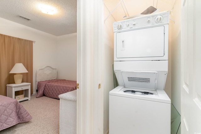 242 Sun Colony Blvd Unit 203, Longs, SC 29568 - clothes washing area featuring laundry area, stacked washing maching and dryer, carpet floors, a textured ceiling, and visible vents
