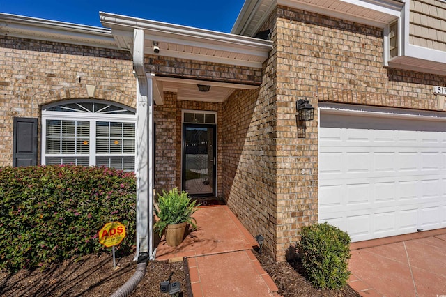 property entrance featuring brick siding and an attached garage