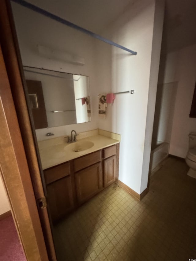 bathroom featuring vanity, tile patterned floors, toilet, and baseboards