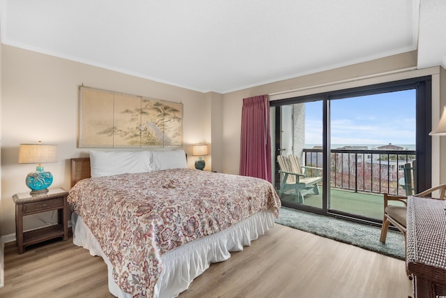 bedroom featuring access to exterior, light wood-style flooring, and crown molding