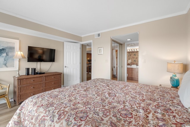 bedroom with visible vents, crown molding, and wood finished floors