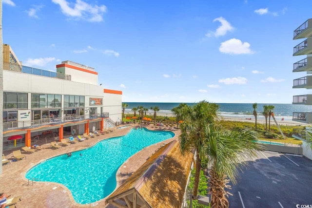 pool with a patio area and a water view