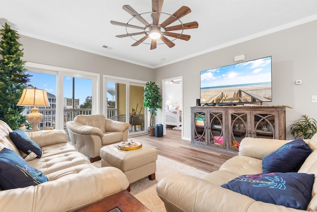 living area with ceiling fan, wood finished floors, visible vents, and ornamental molding