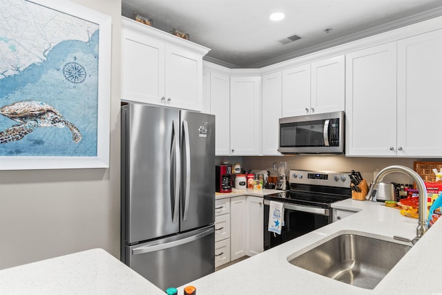 kitchen featuring a sink, light stone countertops, appliances with stainless steel finishes, and white cabinetry