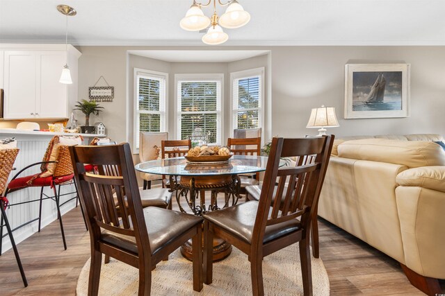 dining space with crown molding and light wood finished floors