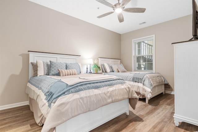 bedroom featuring wood finished floors, visible vents, and baseboards