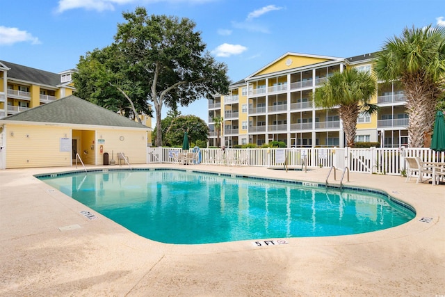 pool with fence and a patio area