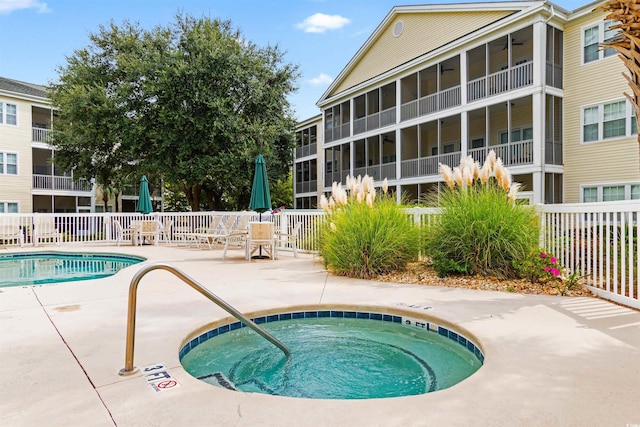 pool featuring a hot tub, a patio, and fence