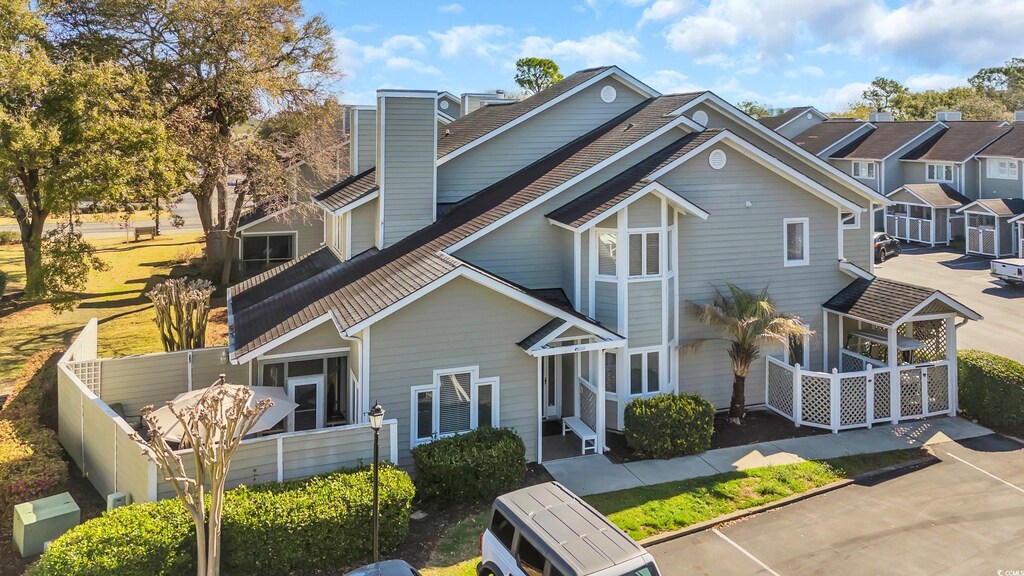 435 Ocean Creek Dr Unit 2705, Myrtle Beach, SC 29572 - view of front of home featuring fence, a chimney, ac unit, and roof with shingles