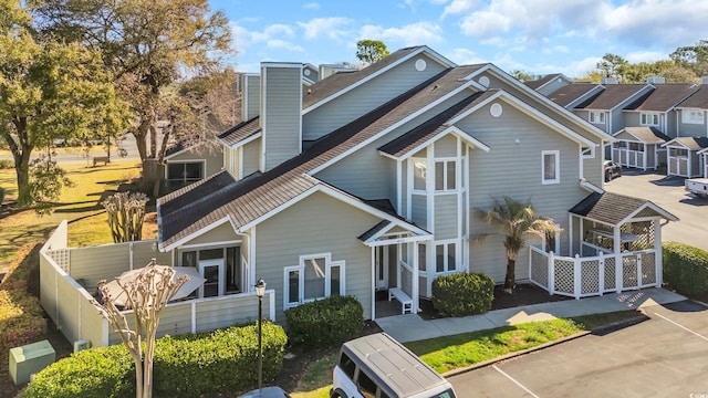 view of front of home featuring fence, a chimney, ac unit, and roof with shingles