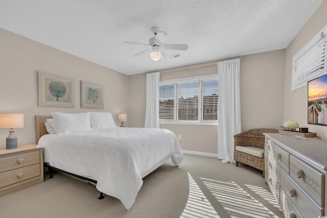 bedroom featuring light colored carpet, a ceiling fan, visible vents, and multiple windows