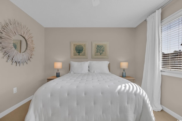 bedroom with baseboards and carpet