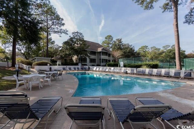 pool featuring fence and a patio area