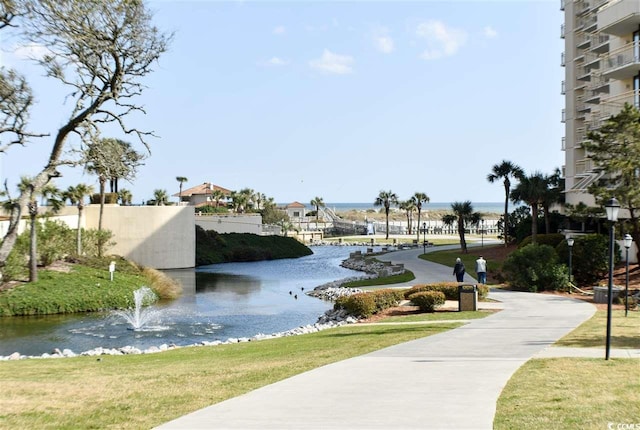 view of home's community featuring a lawn and a water view