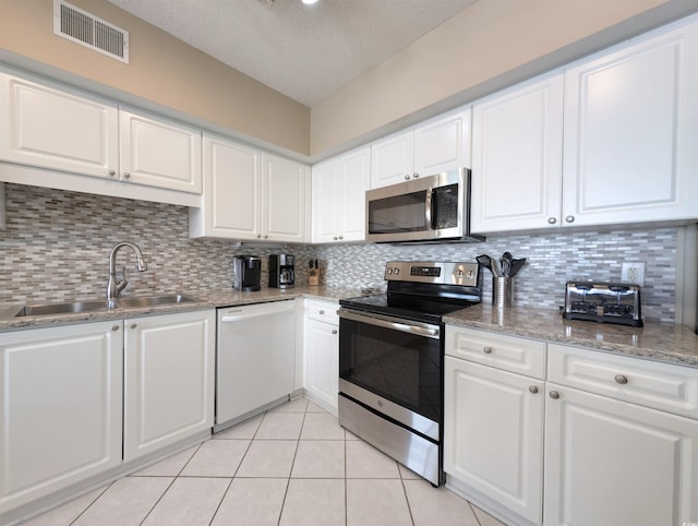 kitchen with white cabinets, visible vents, appliances with stainless steel finishes, and a sink