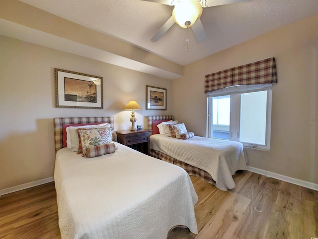 bedroom featuring ceiling fan, baseboards, and wood finished floors