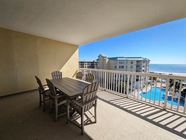 balcony featuring a water view and outdoor dining space