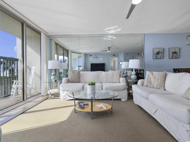 living area with carpet floors, a textured ceiling, floor to ceiling windows, and a ceiling fan