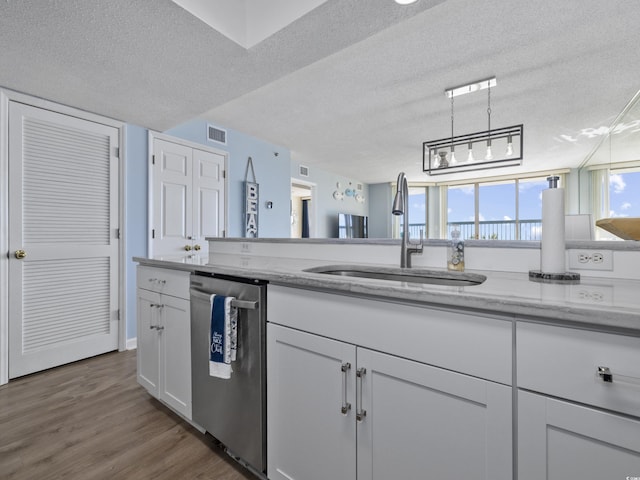 kitchen featuring visible vents, dishwasher, white cabinets, a textured ceiling, and a sink