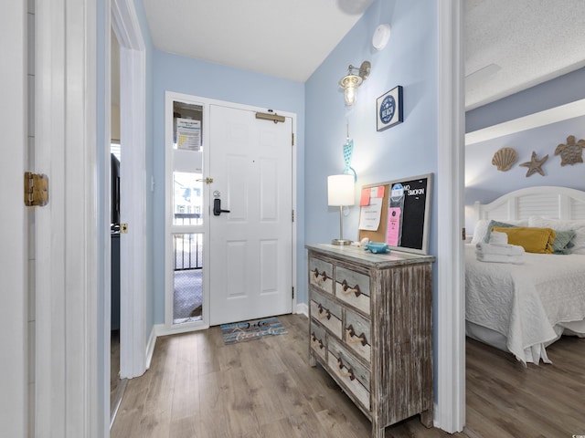 entrance foyer with baseboards and wood finished floors