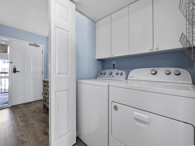 washroom featuring washer and dryer, wood finished floors, cabinet space, and a textured ceiling