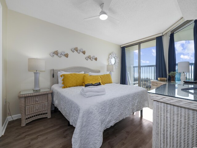 bedroom with expansive windows, wood finished floors, baseboards, access to exterior, and a textured ceiling
